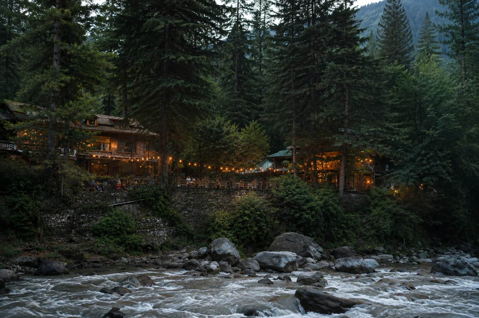 The Dankville lodge glowing at dusk beside the Parvati river